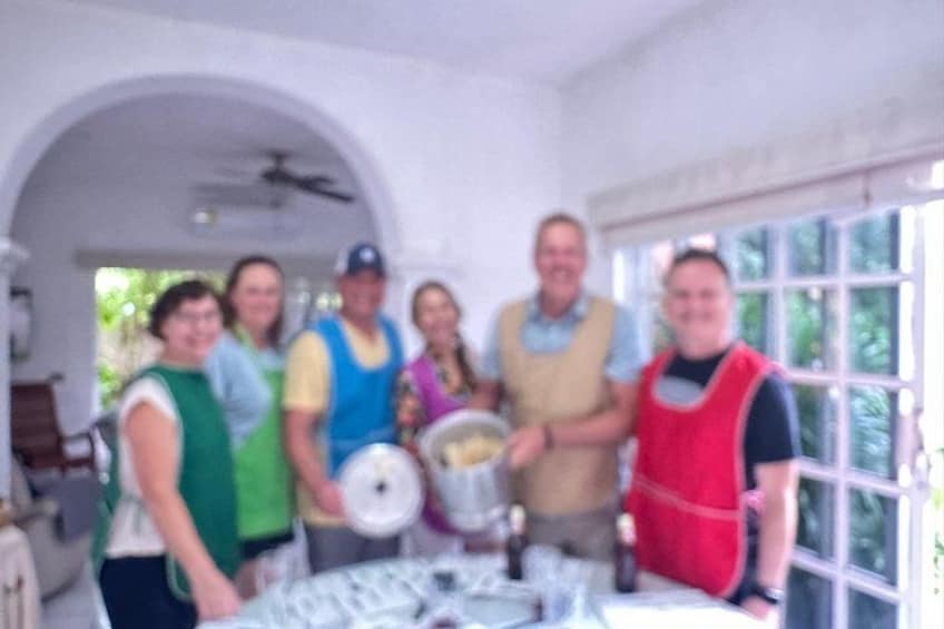 A group of people in a kitchen holding a large pot. 5