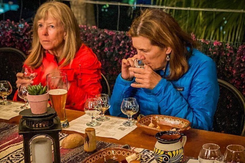 Two people sitting at a table with drinks and a menu. 5