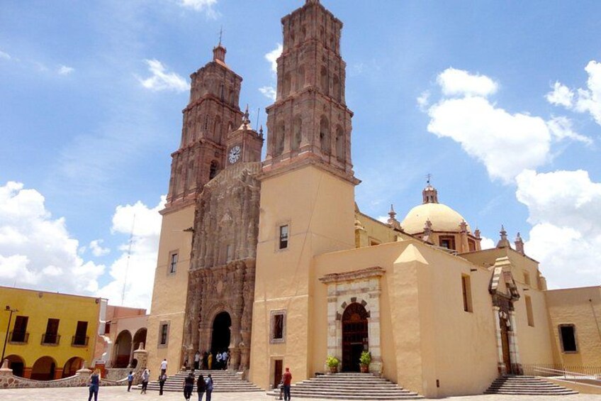 A historic church with two bell towers and a dome. 1