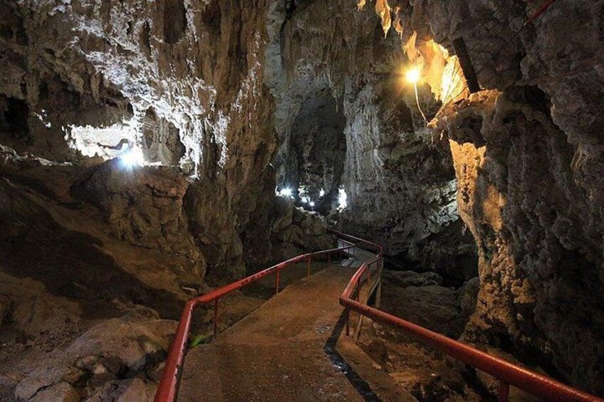 Interior de cueva con escalera metálica y formaciones rocosas. 1