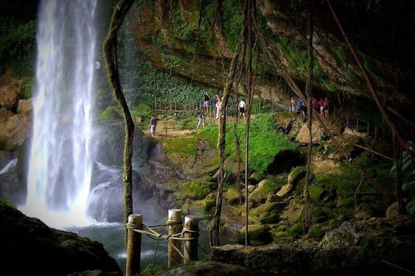 A waterfall, a forested area, and people hiking. 5