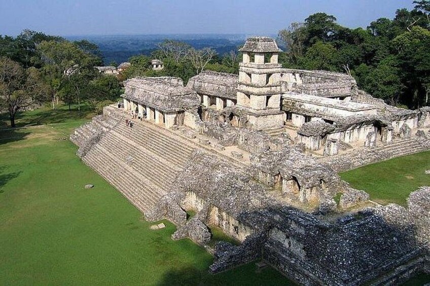 An ancient Mayan pyramid complex with stepped structures and a large open plaza. 5