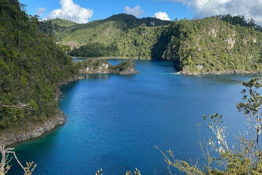 A large body of water surrounded by forested hills. 4