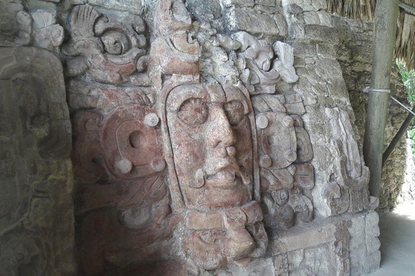 Een stenen sculptuur met ingewikkelde decoraties en een gezicht. 1