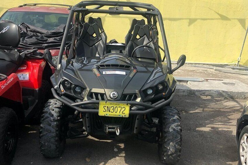 A black ATV with a yellow license plate SN3072 parked next to a red vehicle. 3