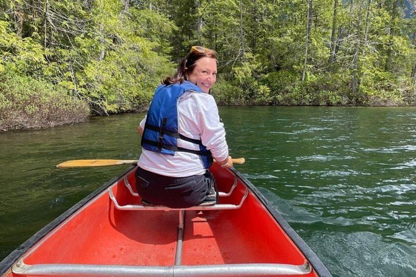 A person in a red canoe on a river surrounded by greenery. 2