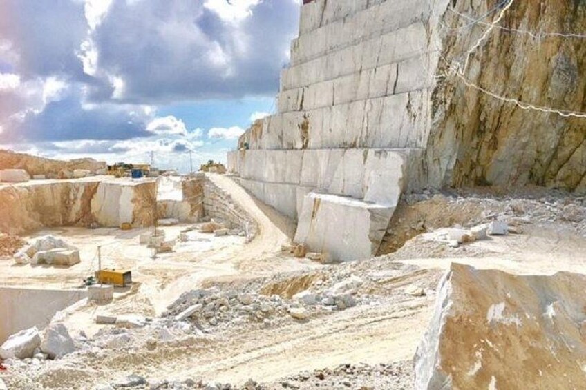 A construction site with large concrete blocks, a dirt path, and a rocky landscape. 1