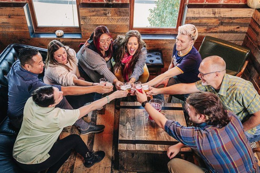 A group of people sitting around a wooden table in a rustic cabin. 5