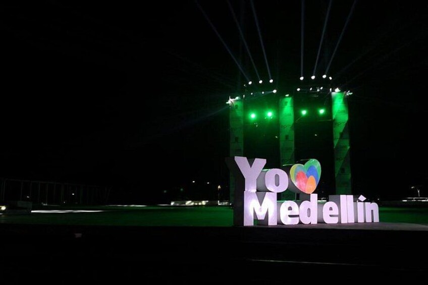 Escena nocturna con un cartel iluminado grande que dice 'Yo Medellín' con un símbolo de corazón. 4