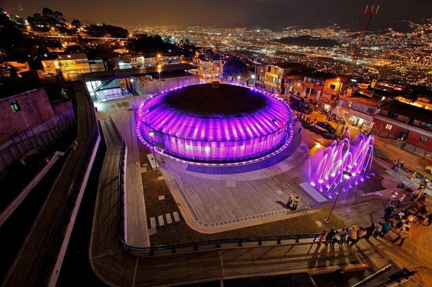 Un estadio con diseño circular, rodeado por un paisaje urbano nocturno. 2