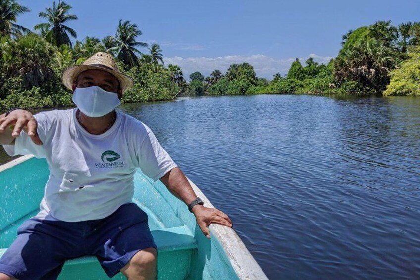 Un homme se trouve dans un bateau sur une rivière paisible, entourée d’une végétation luxuriante. 2