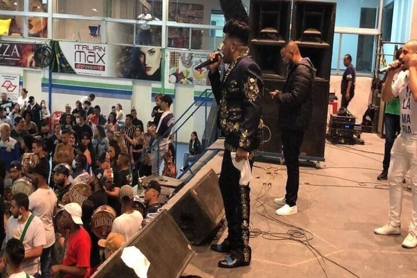 A crowd at an indoor event with a stage and speakers. 4