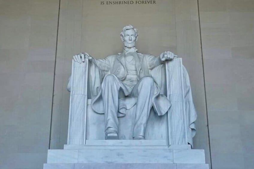 A statue of a seated figure with a draped cloth, inscribed with 'IS ENSHRINED FOREVER.' 1