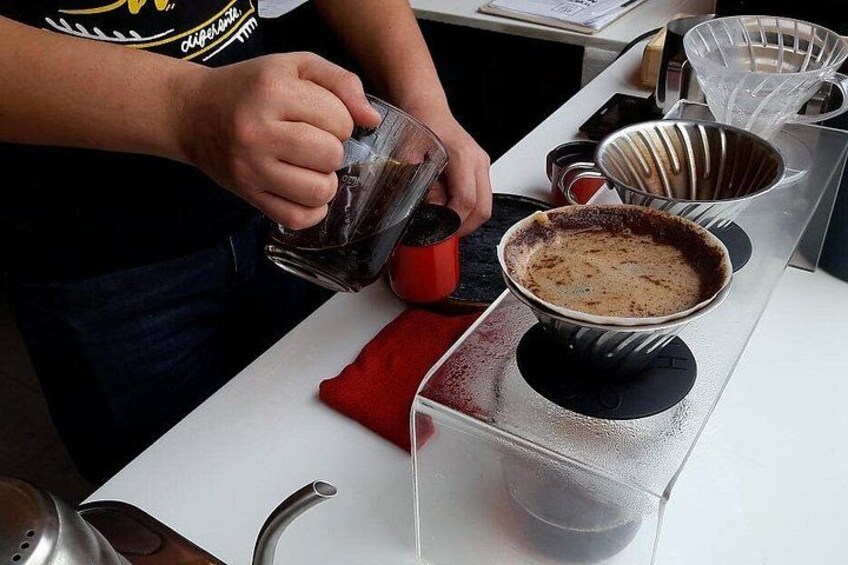A person pouring a liquid into a bowl on a white countertop. 5
