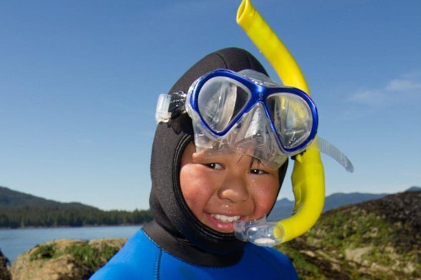 Een persoon in een blauw neopreenpak en snorkeluitrusting, met een gele snorkel. 5