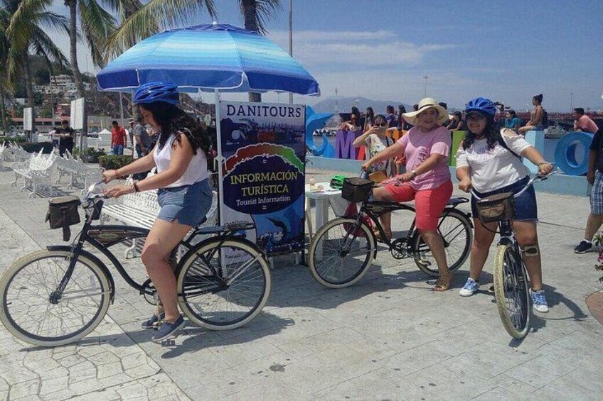 A woman on a bicycle, a woman on a unicycle, and a sign with 'DANITOURS' and 'INFORMATION TURISTICA'. 4