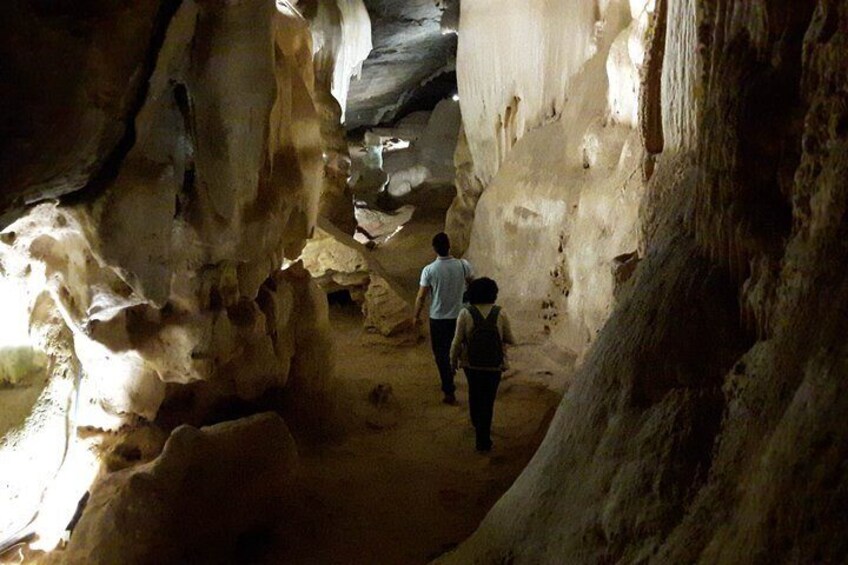 A narrow cave passage with stalactites and stalagmites. 5