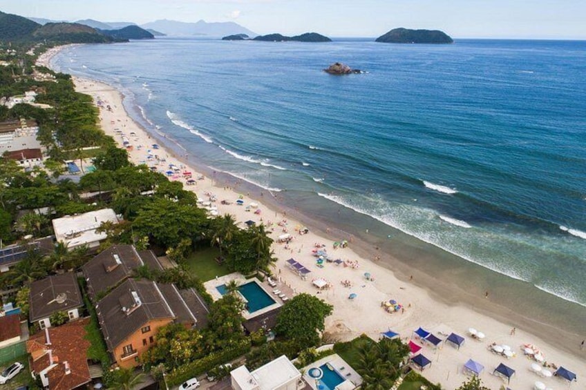A coastal beach with houses, a swimming pool, and umbrellas. 2