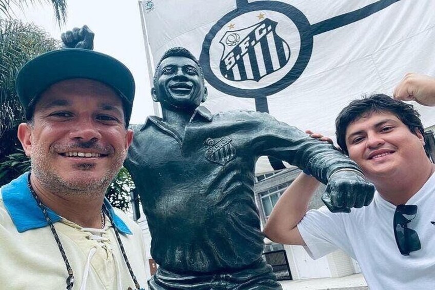 A person taking a photo with a statue of a soccer player. 4