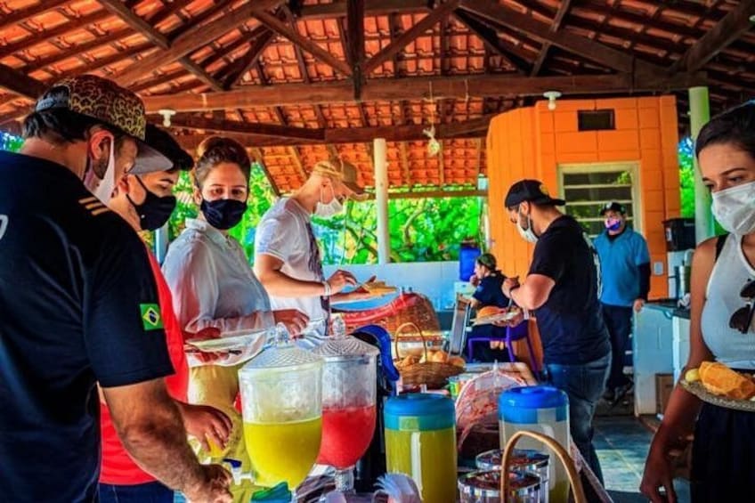 People at a food stall with drinks and food items. 1