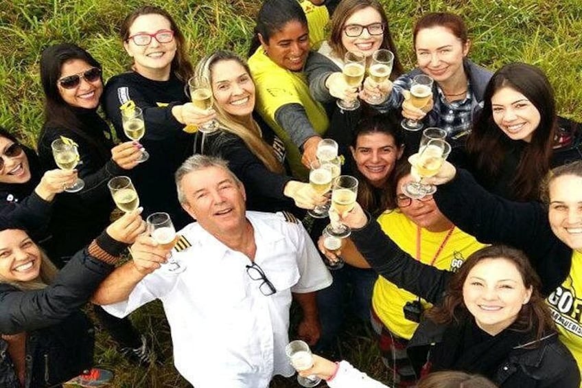 A group of people toasting with champagne glasses outdoors. 5