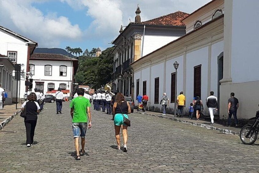 A cobblestone street with people walking, historic buildings, and a bicycle parked on the right. 4