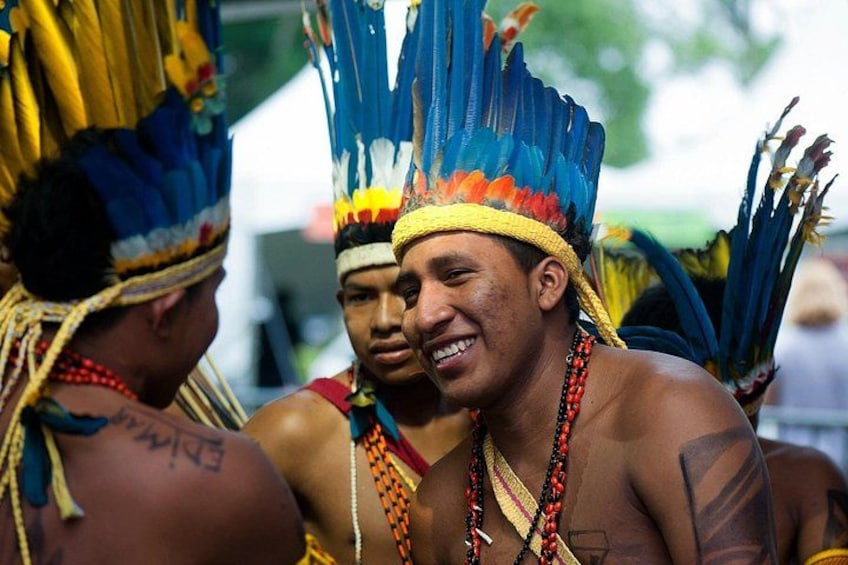 Individuals wearing traditional headdresses with feathers and beads. 1