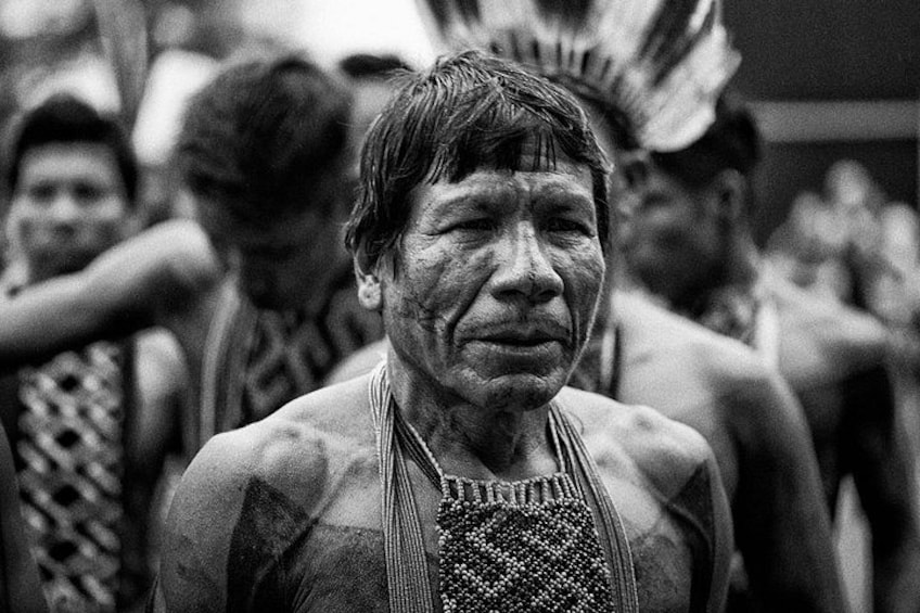 A person with a necklace and feathered headdress, likely part of a cultural or traditional event. 5