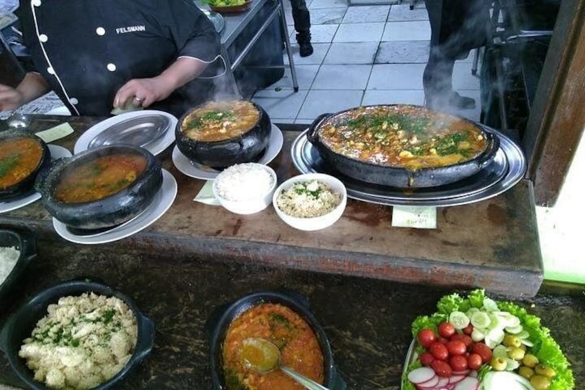 A variety of dishes, including a large pot of stew, bowls of rice, and a salad with vegetables. 2