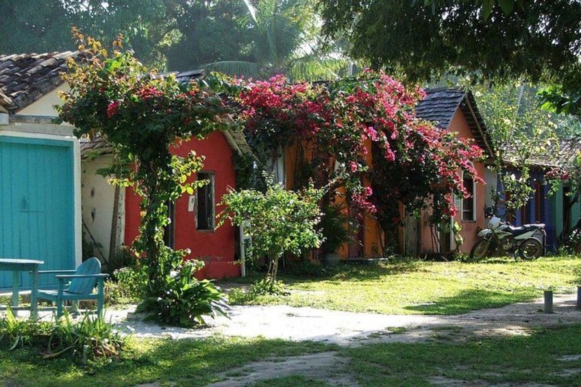 A red house with pink flowers, a blue chair, and a motorcycle. 5