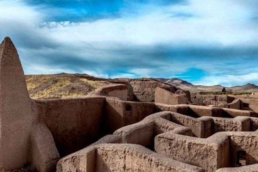 Ancient ruins with stone structures and a mountainous landscape. 5