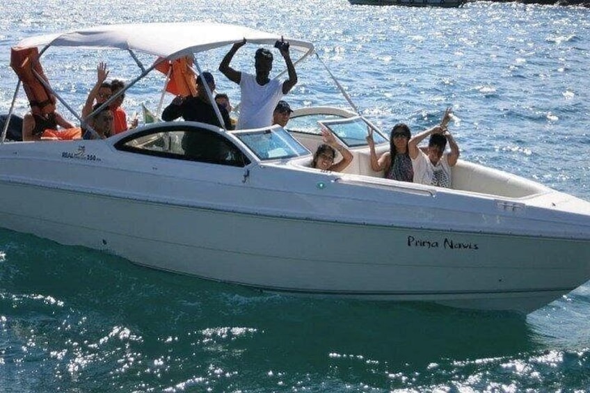 Un bateau à moteur blanc, portant le nom « Prina Navis » sur sa coque, transportait plusieurs passagers. 3
