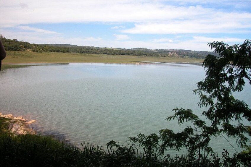 A large body of water surrounded by greenery and hills. 5