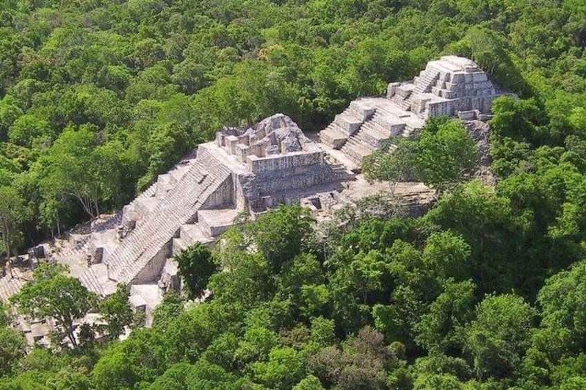 An ancient Mayan pyramid complex surrounded by dense forest. 3