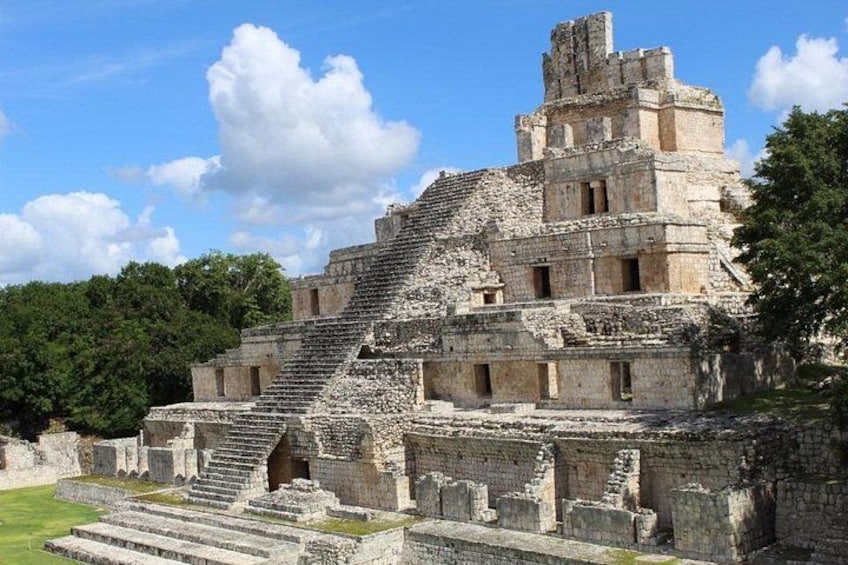 Eine große, uralte Pyramide mit einer Treppe, die zum Gipfel führt, umgeben von üppiger Vegetation. 3