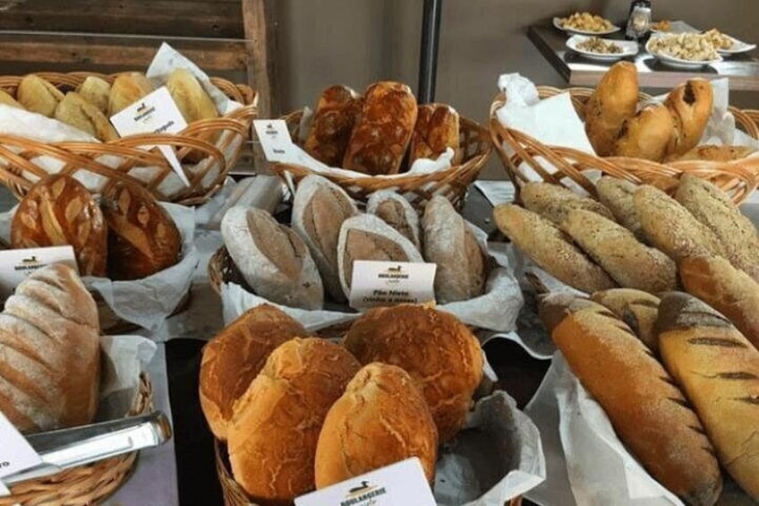 A variety of breads displayed in baskets and on trays. 5