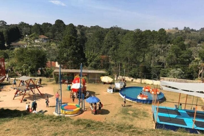 A playground with swings, slides, and a pool with inflatable rings. 3