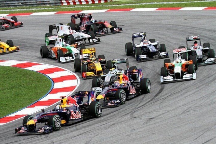 A Formula 1 race with multiple cars on a track. 4