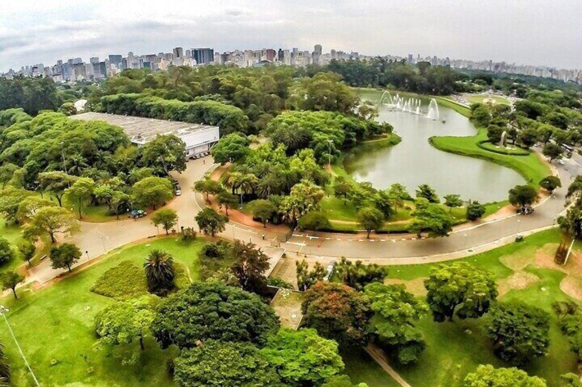 A park with a lake, fountains, and a city skyline in the background. 3