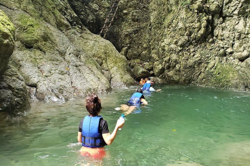 Personas vadeando un río en un cañón rocoso. 1