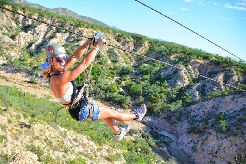 A person zip-lining over a mountainous terrain. 3