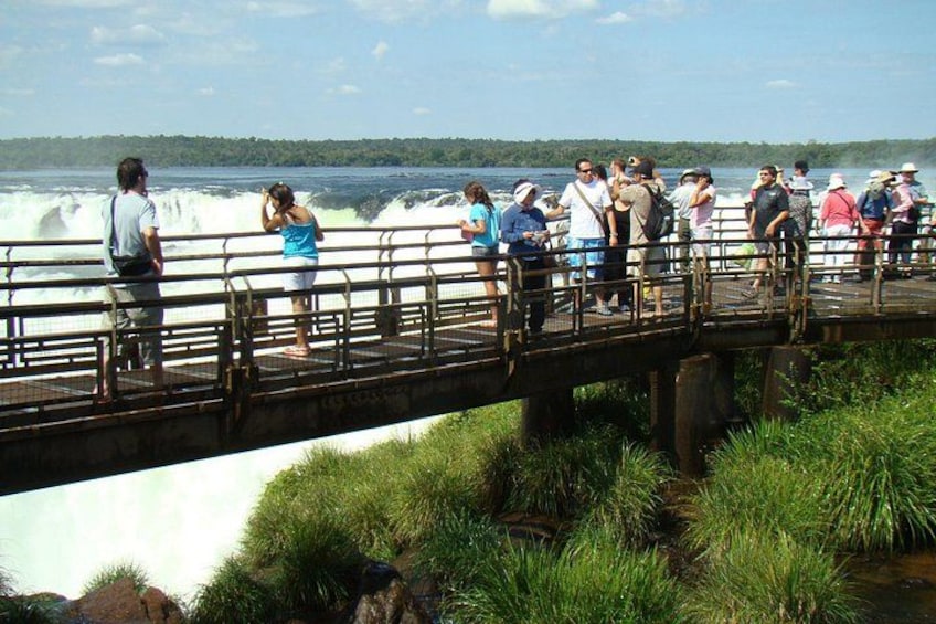 A bridge with people observing a waterfall. 3