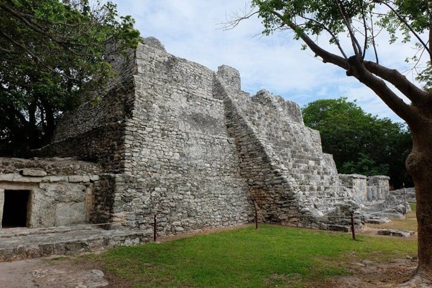 Ancient stone ruins with a staircase, surrounded by grass and trees. 4