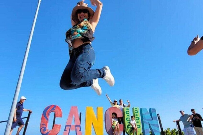 A person jumping in the air with a colorful background and the word 'CANCUN' visible. 5