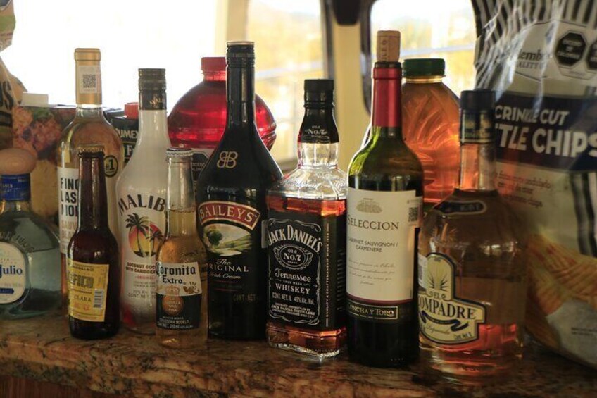 A variety of liquor bottles on a counter. 4