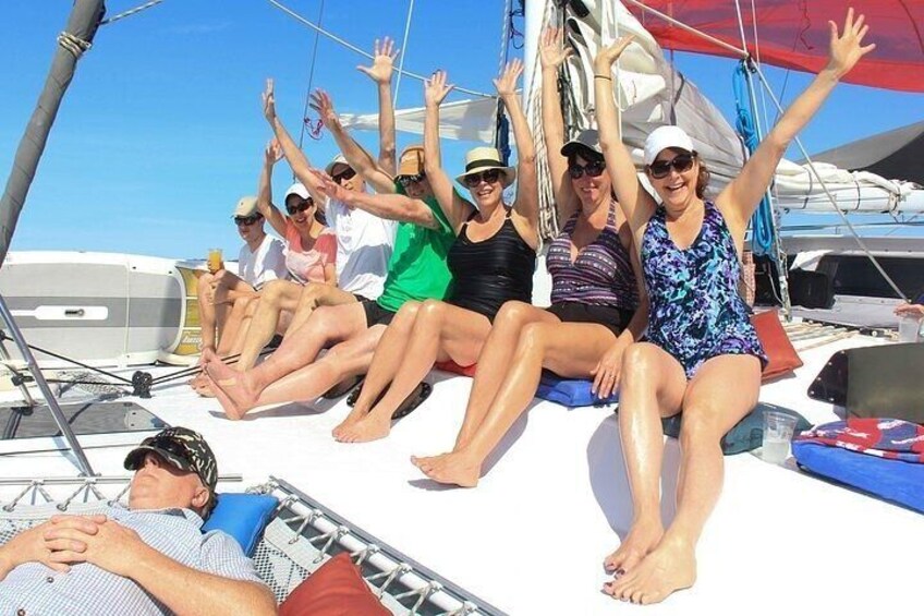 A group of people on a sailboat with sails and rigging visible. 2