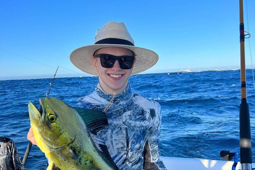 A person holding a fish on a boat with the ocean in the background. 2