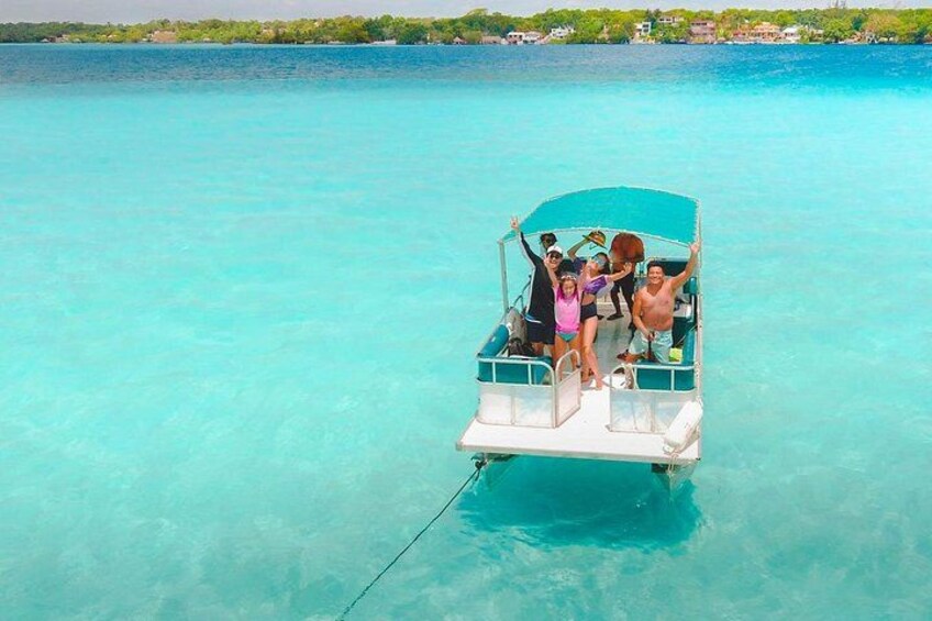 A small boat with people on a turquoise sea. 1