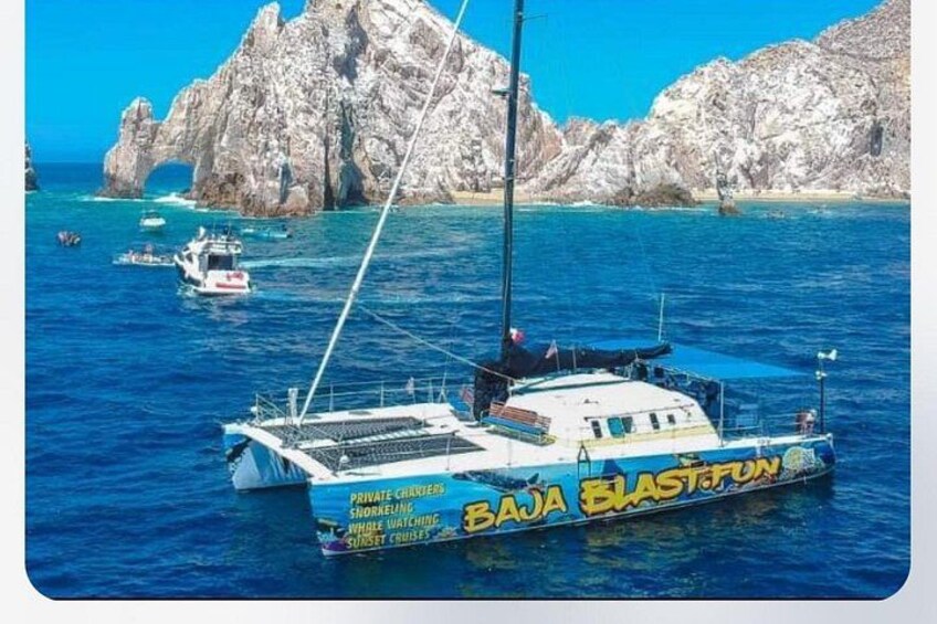 A boat named 'BAJA BLASTFUNK' with a rocky coastline and clear blue water in the background. 5
