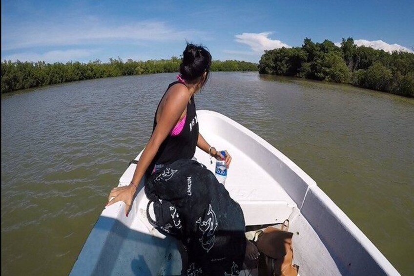 A person in a boat on a river with greenery on the banks. 2